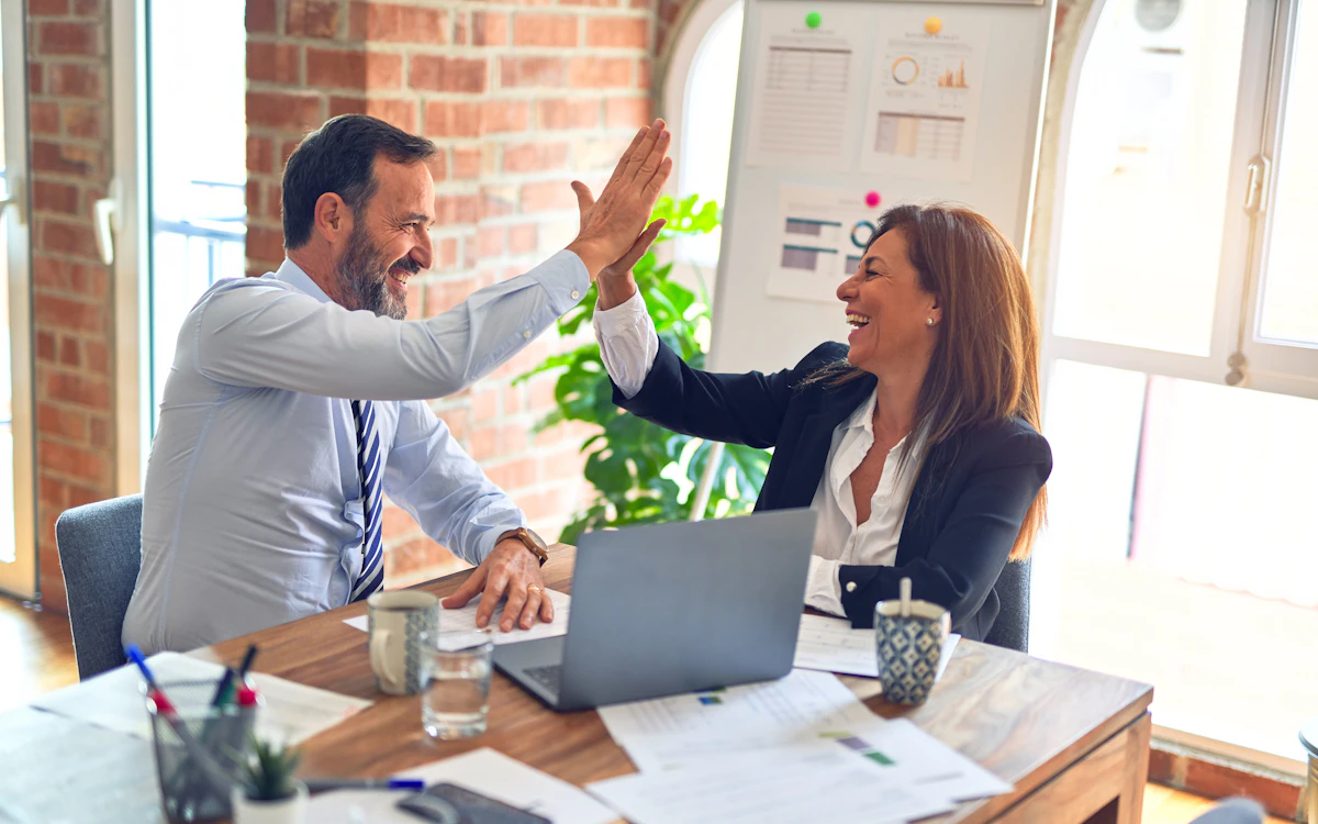 Two people meeting across a desk in conversation, representing a charity selecting a fundraising agency